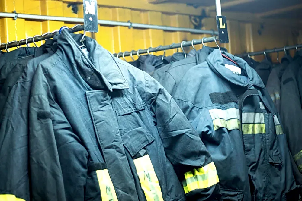 Спецодежда висит на рейлингах в ожидании стирки в прачечной для спецодежды